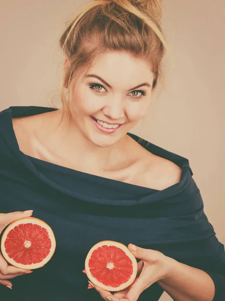 Жінка тримає червоний грейпфрут на грудях — стокове фото