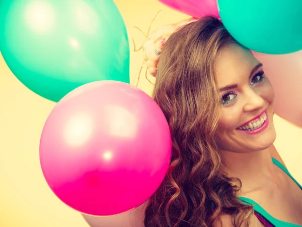Kvinna som håller ett gäng färgglada ballonger — Stockfoto