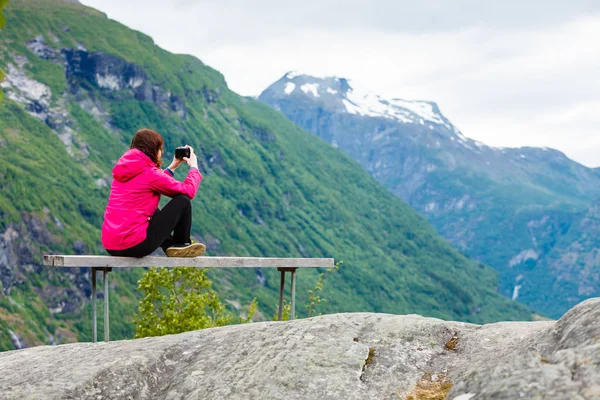 Turista con cámara mirando a la vista panorámica en las montañas Noruega — Foto de Stock