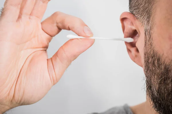 Homme enlevant la cire de l'oreille en utilisant Q-tip — Photo