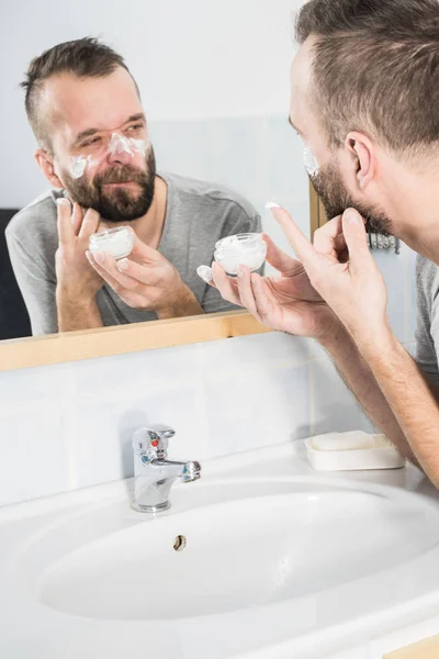 男性浴室で保湿クリームを適用します。 — ストック写真