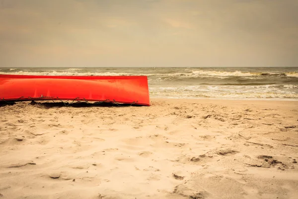 Оранжевая лодка на песчаном пляже — стоковое фото