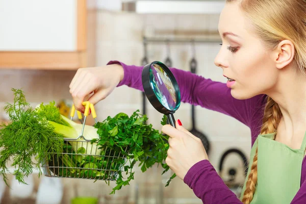 Woman looking through magnifier at vegetables basket — Stock Photo, Image