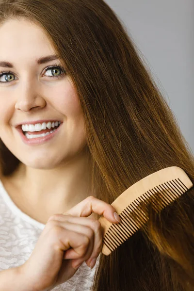 Mulher feliz escovando seu cabelo — Fotografia de Stock