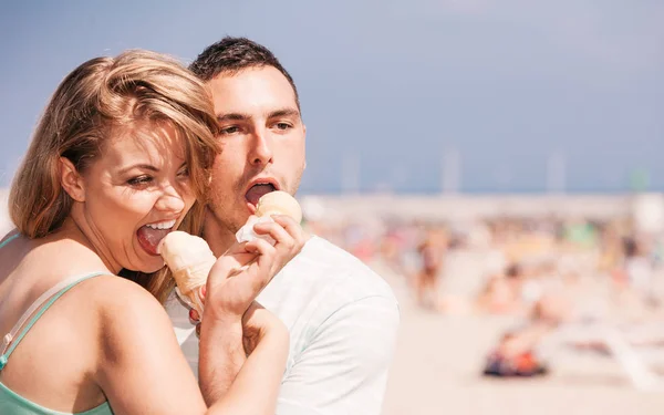 Mężczyzna i kobieta jedzący lody na plaży — Zdjęcie stockowe