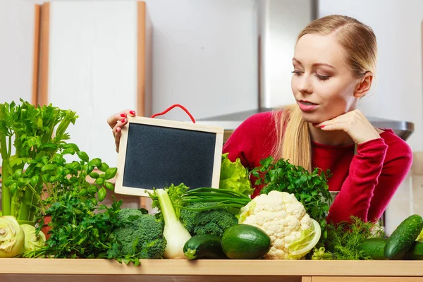 Жінка з зеленими овочами тримає дошку — стокове фото