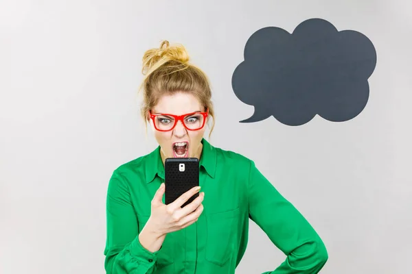 Angry business woman looking at phone, thinking bubble — Stock Photo, Image