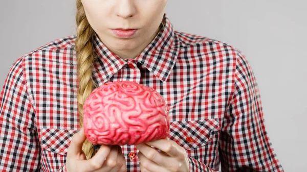 Mujer pensando y sosteniendo cerebro falso — Foto de Stock