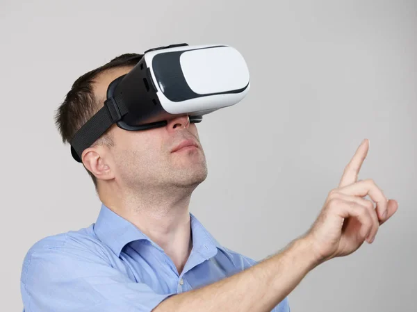 Hombre con gafas de realidad virtual en gris —  Fotos de Stock