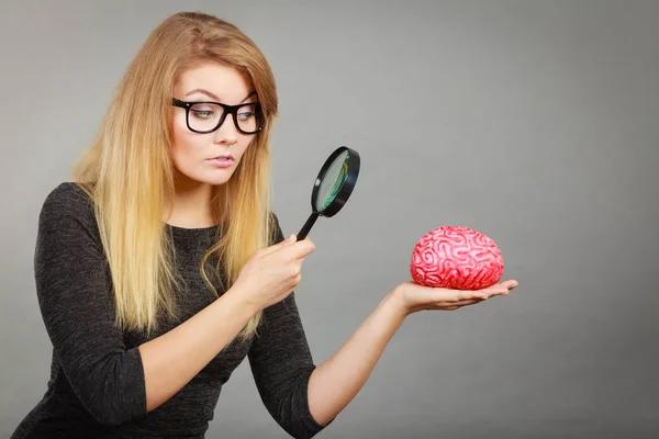 脳を調べる虫眼鏡を保持している女性 — ストック写真