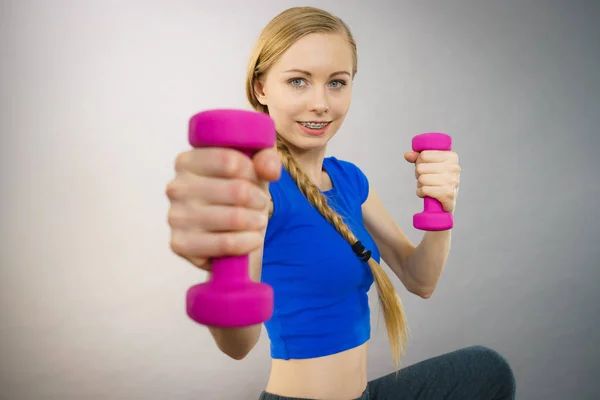 Teenage woman working out at home with dumbbell — Stock Photo, Image