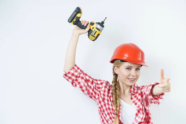 Frau trägt Helm mit Bohrmaschine — Stockfoto