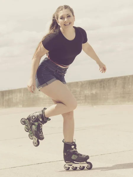 Ευτυχισμένη νεαρή γυναίκα που φοράει πατίνια — Φωτογραφία Αρχείου