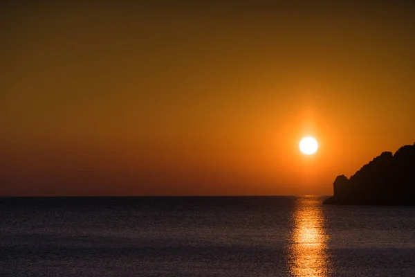 Puesta o salida del sol sobre la superficie del mar — Foto de Stock