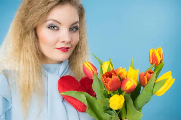 Mulher segura tulipas e coração vermelho — Fotografia de Stock