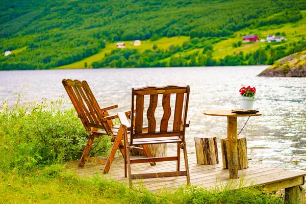 Odpočívadlem oblast piknik chaires na břehu jezera fjord — Stock fotografie