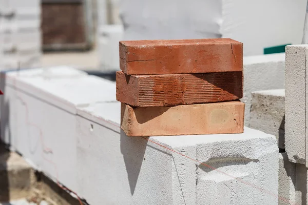Pila de ladrillos de color naranja en el sitio de construcción —  Fotos de Stock