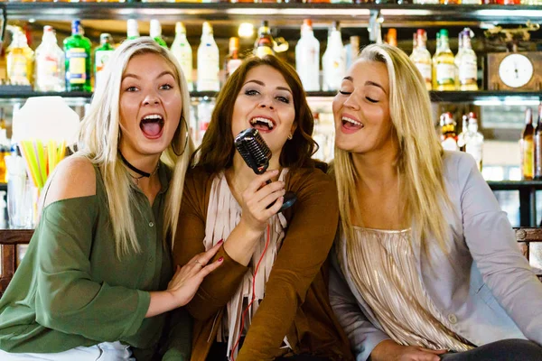 Женщины в баре поют караоке — стоковое фото