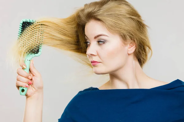 Femme brossant ses cheveux longs avec une brosse — Photo