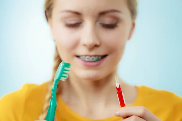 Menina com aparelho de dentes usando escova interdental e tradicional — Fotografia de Stock