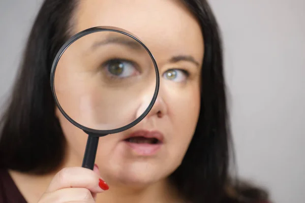 Adult woman with magnifying glss — Stock Photo, Image