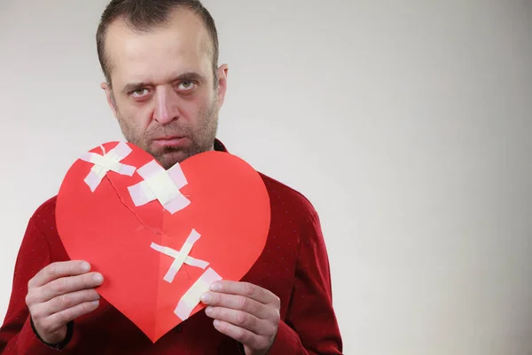 Triste hombre adulto sosteniendo el corazón roto —  Fotos de Stock