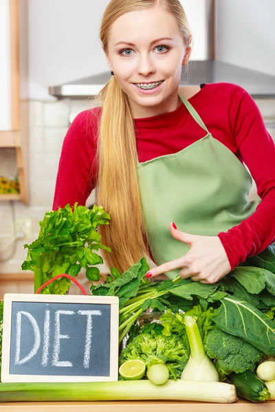 Femme dans la cuisine ayant des légumes de régime vert — Photo