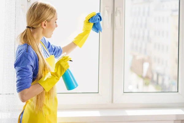 Жінка прибирає вікно вдома — стокове фото