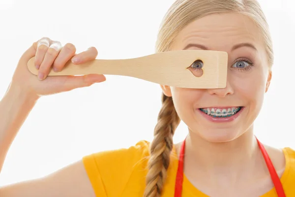 Woman holding wooden spatula with heart — Stock Photo, Image