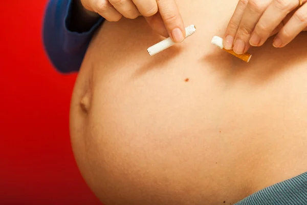Těhotná žena s velkou žaludek prolomit cigaret — Stock fotografie