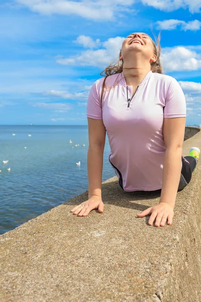 Deniz yanında yoga yaparken kadın — Stok fotoğraf