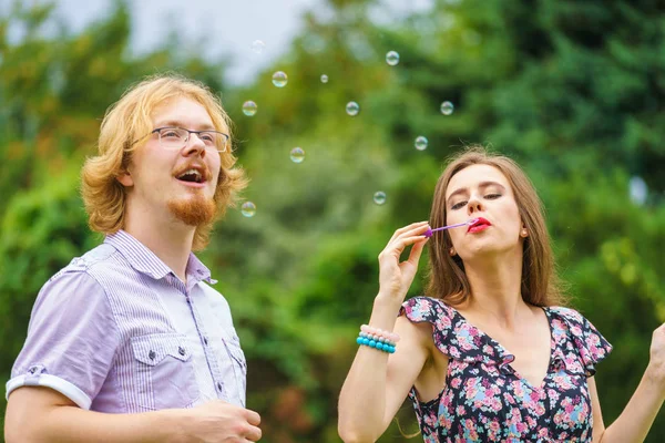 Pareja soplando burbujas de jabón, divirtiéndose —  Fotos de Stock