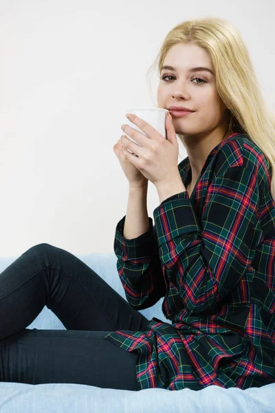 Mulher adolescente sentada no sofá com caneca — Fotografia de Stock