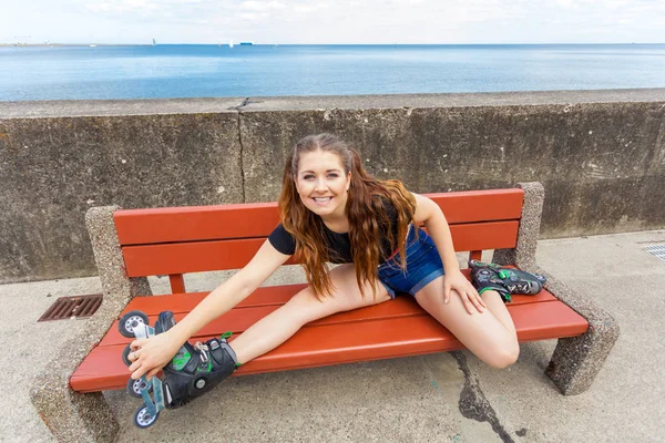 Glimlachend meisje met rolschaatsen buiten — Stockfoto