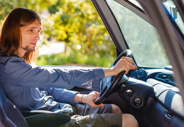 Aburrido joven con pelo largo coche de conducción — Foto de Stock