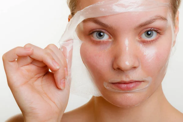 Kvinna att ta bort facial peel off mask. — Stockfoto