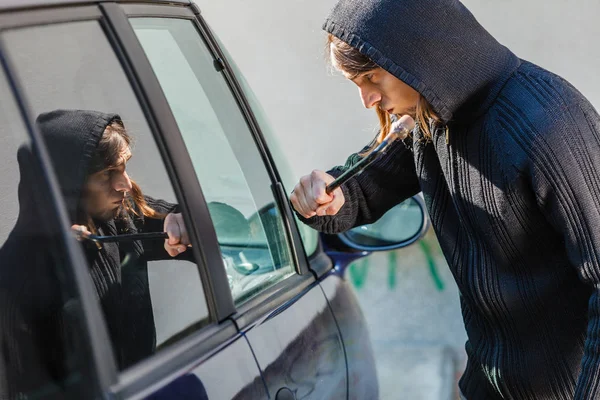 Ladrón ladrón rompiendo la ventana del coche — Foto de Stock