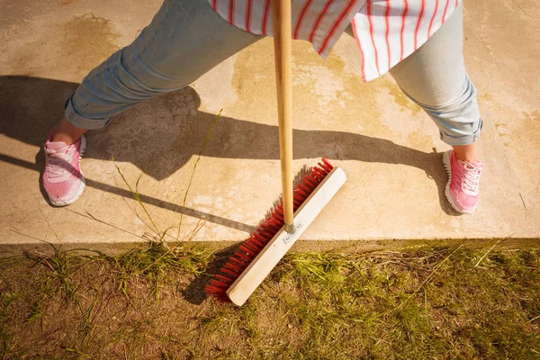 Person cleaning patio using brush broom — Stock Photo, Image