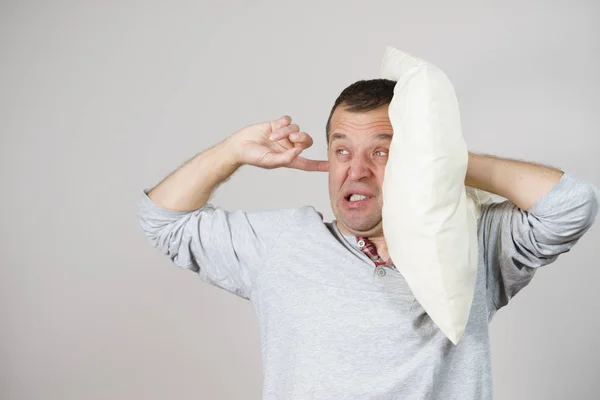 Hombre somnoliento con almohada cerrando su oreja — Foto de Stock