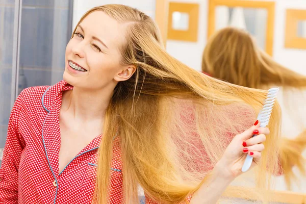 Femme peigner ses cheveux longs dans la salle de bain — Photo