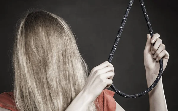 Суицидальная женщина рядом с веревкой с узлом — стоковое фото