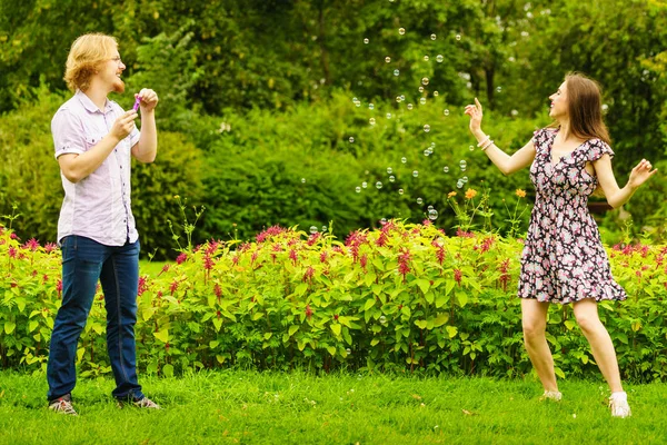 Couple blowing bubbles outdoor — Stock Photo, Image