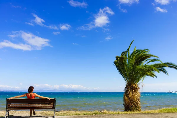 Tourist woman on bench enjoying sea view — Stock Photo, Image