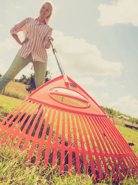 Unusual angle of woman raking leaves