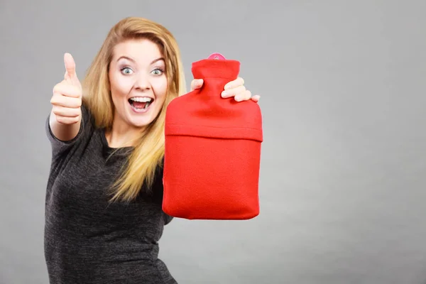 Mujer feliz sostiene botella de agua caliente — Foto de Stock