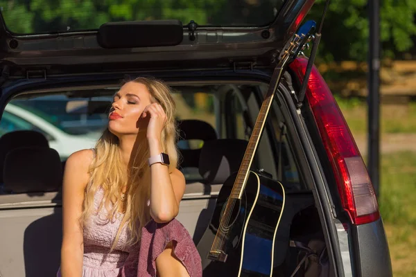 Hippie vrouw met gitaar in van auto — Stockfoto