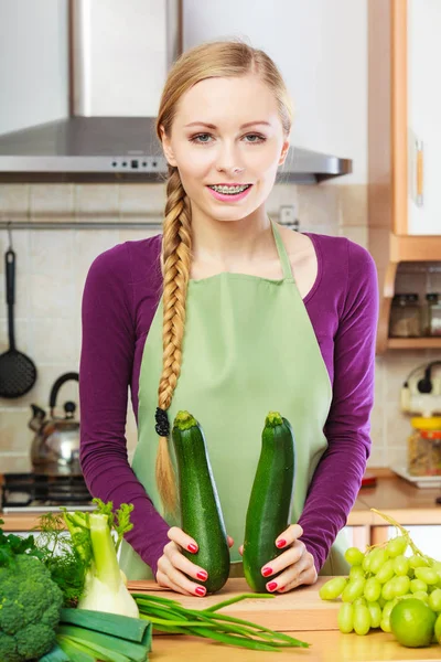 Mulher dona de casa na cozinha com legumes verdes — Fotografia de Stock