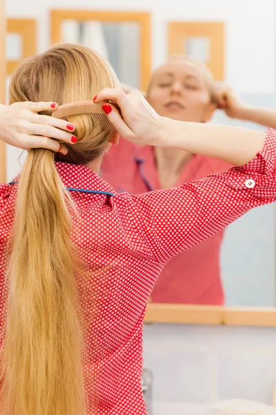 Frau kämmt ihre langen Haare im Badezimmer — Stockfoto