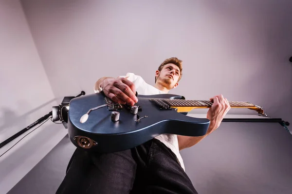 Joven está tocando la guitarra eléctrica — Foto de Stock