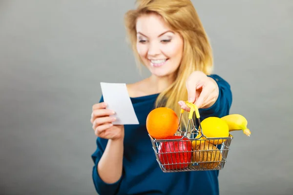 Mujer feliz sosteniendo cesta de la compra con frutas —  Fotos de Stock